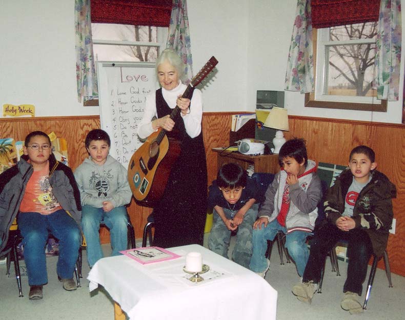 Sister playing guitar to students
