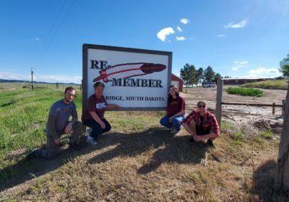 students posing in front of sign